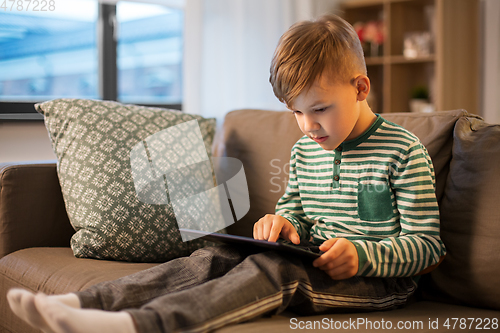 Image of happy little boy with tablet computer at home