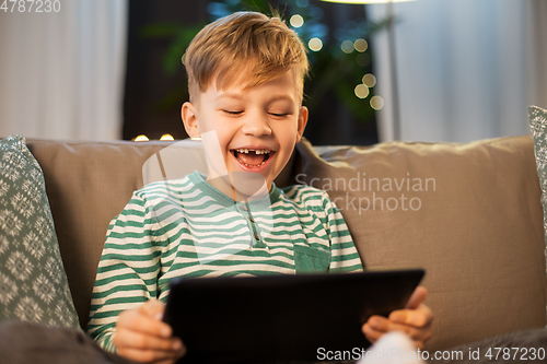 Image of happy little boy with tablet computer at home