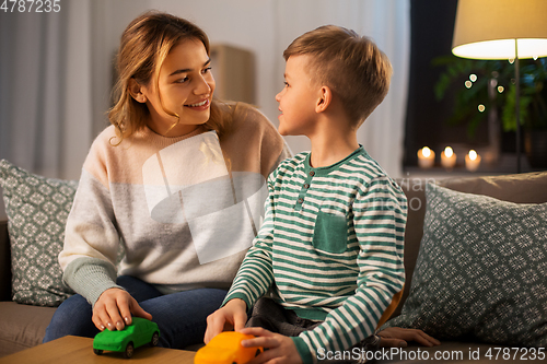 Image of mother and son playing with toy cars at home