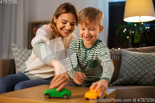 Image of mother and son playing with toy cars at home