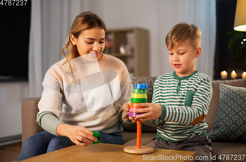 Image of mother and son playing with toy pyramid at home