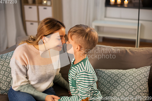 Image of happy mother and son touching noses at home