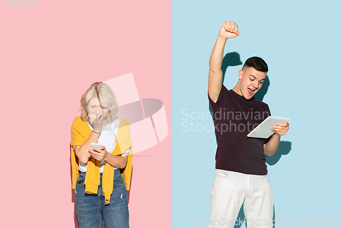 Image of Young emotional man and woman on pink and blue background