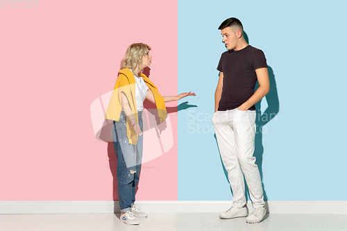 Image of Young emotional man and woman on pink and blue background