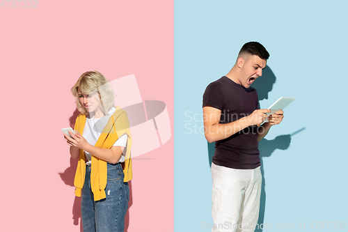 Image of Young emotional man and woman on pink and blue background