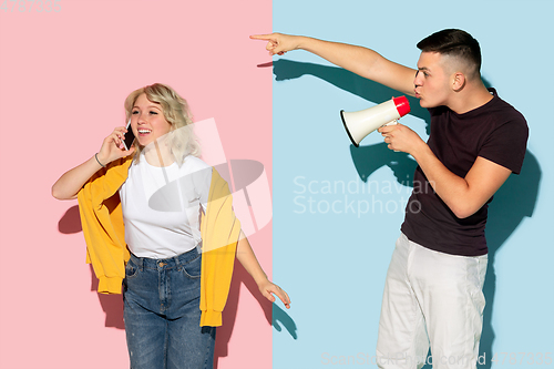 Image of Young emotional man and woman on pink and blue background