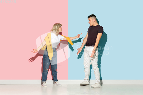 Image of Young emotional man and woman on pink and blue background
