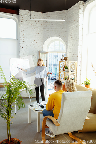 Image of Interior designer working with young couple. Lovely family and professional designer or architector.