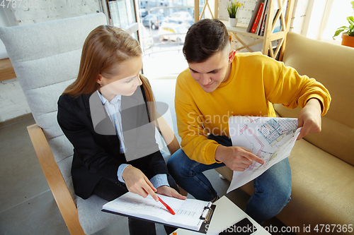 Image of Interior designer working with young couple. Lovely family and professional designer or architector.