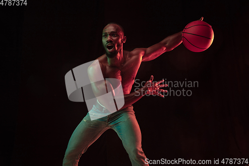 Image of Young african-american basketball player against dark background