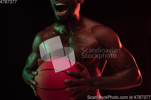 Image of Young african-american basketball player against dark background