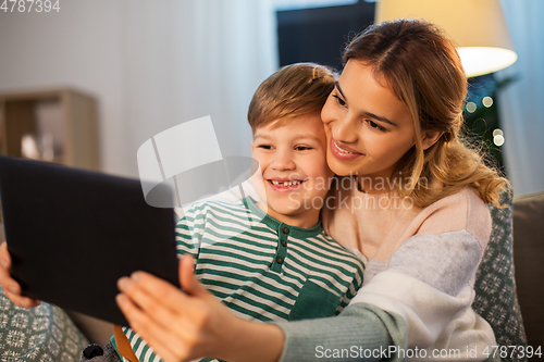 Image of mother and son using tablet computer at home