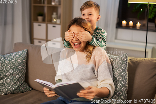 Image of happy smiling mother playing with her son at home