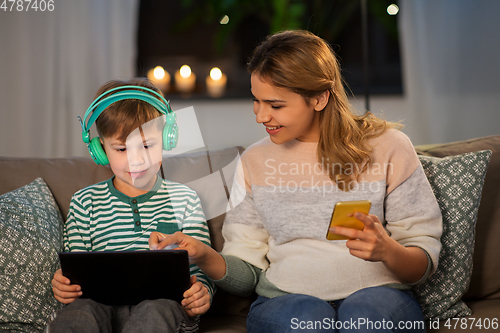 Image of mother and son using gadgets at home