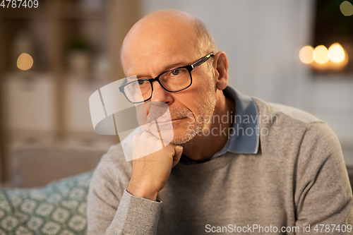 Image of sad senior man in glasses thinking at home