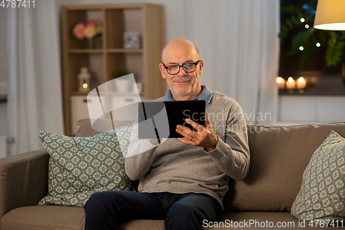 Image of happy senior man with tablet computer at home