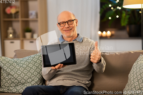 Image of happy senior man with tablet computer at home