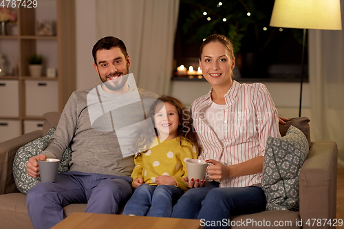 Image of portrait of happy family sitting on sofa at home