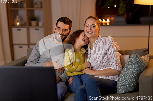 Image of happy family watching tv at home at night