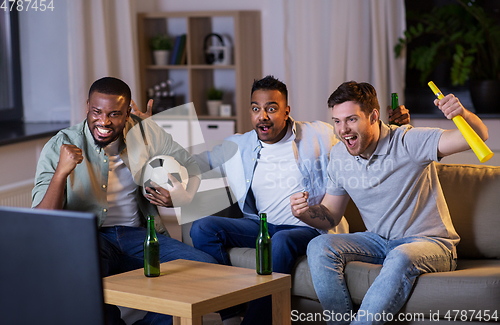 Image of friends with ball and vuvuzela watching soccer