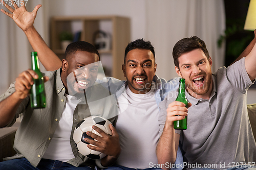 Image of friends or soccer fans with ball and beer at home