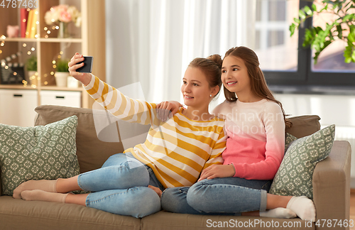 Image of happy girls taking selfie with smartphone at home