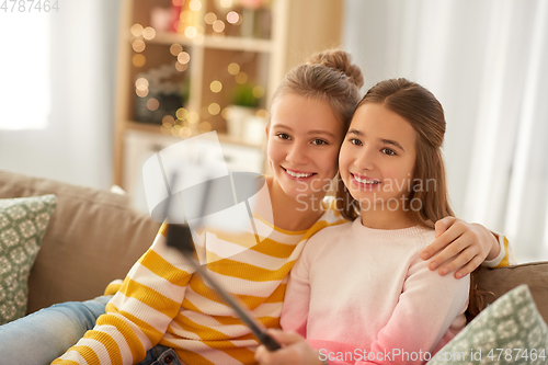 Image of happy girls taking selfie with smartphone at home