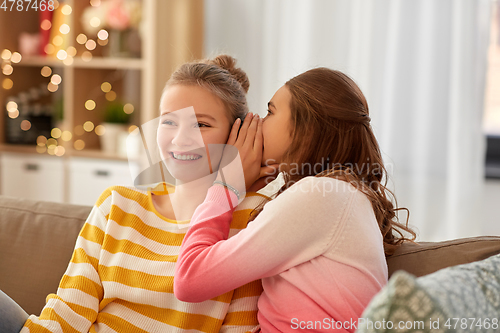 Image of happy teenage girls gossiping at home