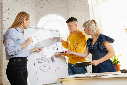 Image of Interior designer working with young couple. Lovely family and professional designer or architector.