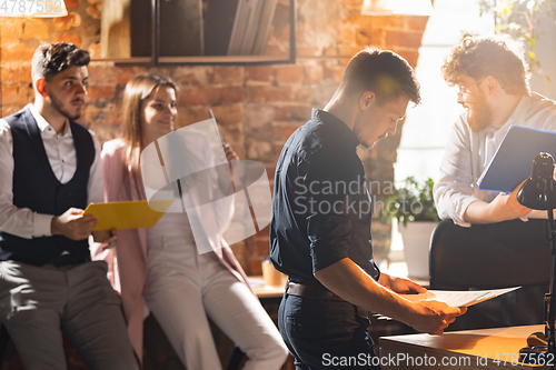 Image of Colleagues working together in modern office using devices and gadgets during creative meeting