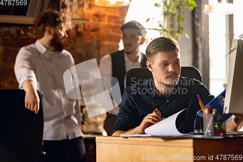 Image of Colleagues working together in modern office using devices and gadgets during creative meeting