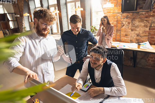 Image of Colleagues working together in modern office using devices and gadgets during creative meeting