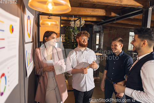 Image of Colleagues working together in modern office using devices and gadgets during creative meeting