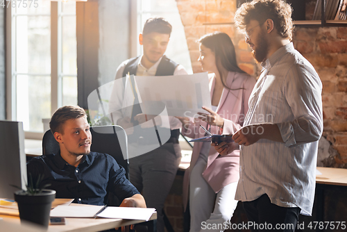 Image of Colleagues working together in modern office using devices and gadgets during creative meeting