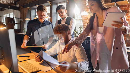 Image of Colleagues working together in modern office using devices and gadgets during creative meeting