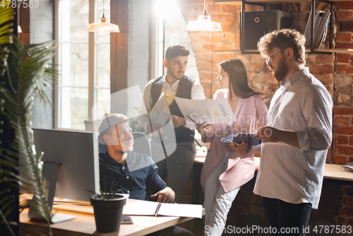 Image of Colleagues working together in modern office using devices and gadgets during creative meeting