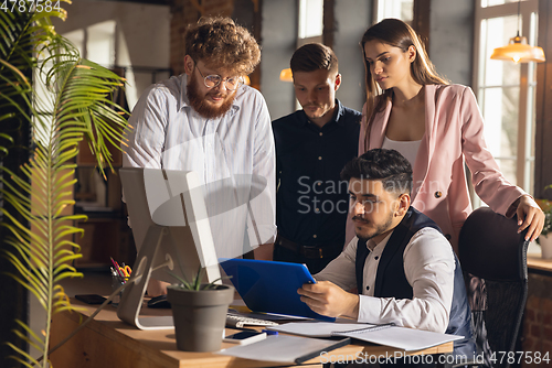 Image of Colleagues working together in modern office using devices and gadgets during creative meeting