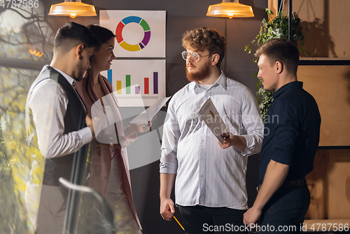 Image of Colleagues working together in modern office using devices and gadgets during creative meeting