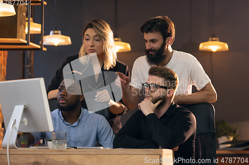 Image of Colleagues working together in modern office using devices and gadgets during creative meeting