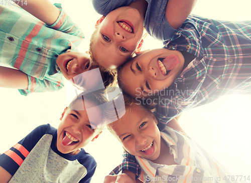 Image of group of happy children showing tongue in circle