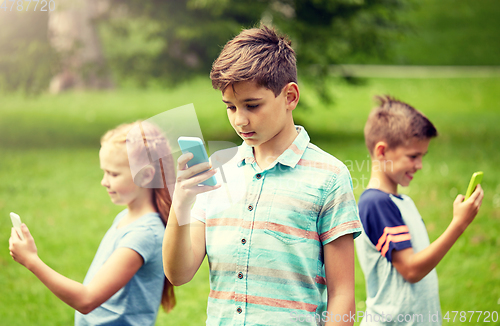 Image of kids with smartphones playing game in summer park