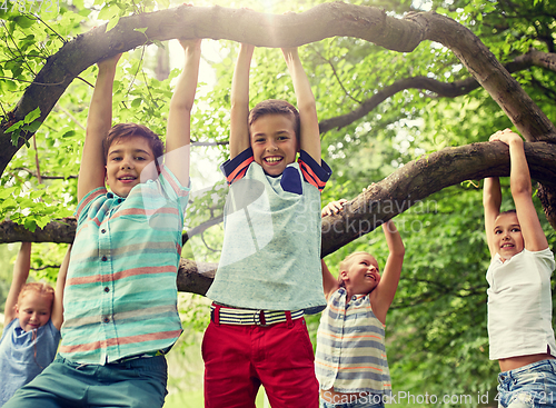 Image of happy kids hanging on tree in summer park