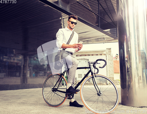 Image of man with bicycle and smartphone on city street