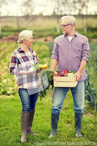 Image of senior couple with box of vegetables on farm