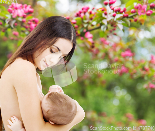 Image of mother breastfeeding her baby over garden