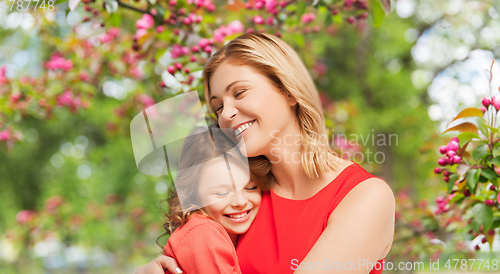 Image of happy mother and daughter hugging over garden