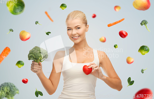 Image of happy smiling young woman with heart and broccoli