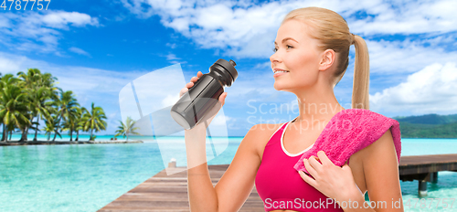Image of happy smiling woman with sports bottle and towel