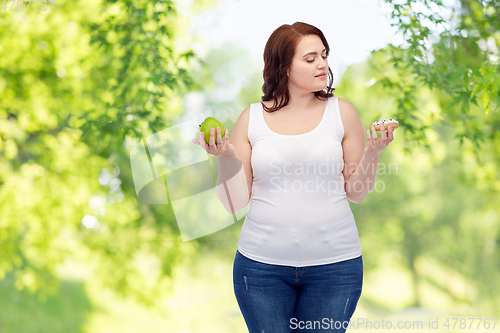 Image of plus size woman choosing between apple and donut