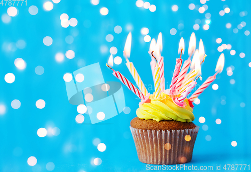 Image of birthday cupcake with many burning candles